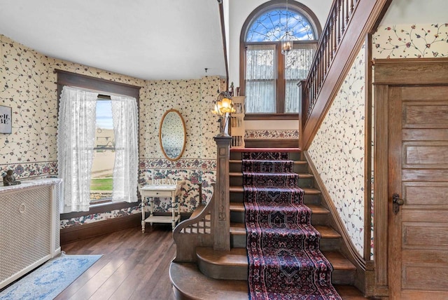 stairs featuring hardwood / wood-style flooring, plenty of natural light, baseboards, and wallpapered walls