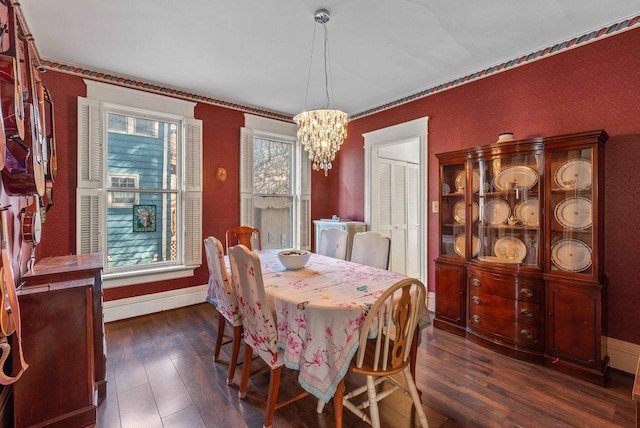 dining area featuring baseboards, a chandelier, and dark wood-style floors