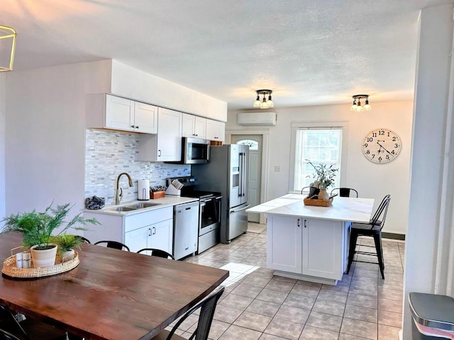 201 S Beaumont Rd, Prairie Du Chien, WI 53821 - kitchen featuring a center island, a sink, light countertops, appliances with stainless steel finishes, and a wall mounted AC