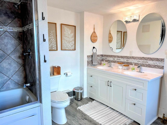 201 S Beaumont Rd, Prairie Du Chien, WI 53821 - bathroom with a sink, double vanity, toilet, and wood finished floors