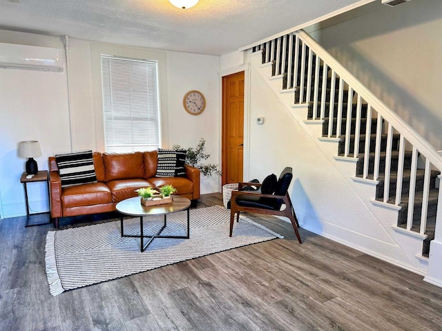 201 S Beaumont Rd, Prairie Du Chien, WI 53821 - living area featuring a wall mounted air conditioner, a textured ceiling, baseboards, wood finished floors, and stairway