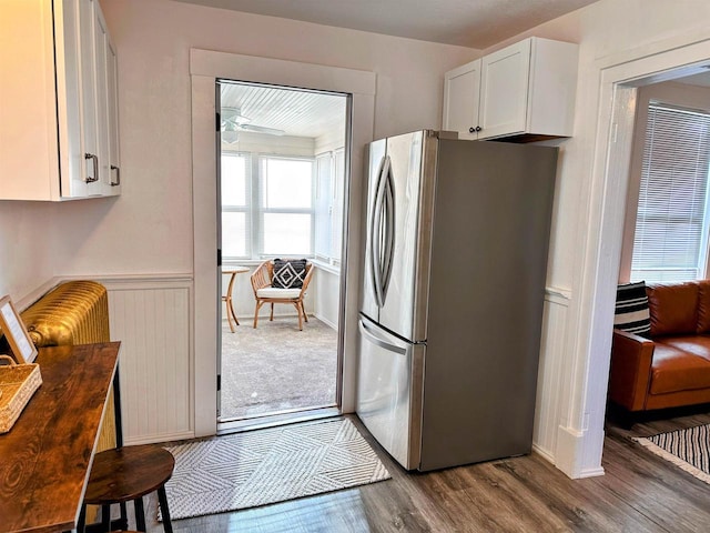 201 S Beaumont Rd, Prairie Du Chien, WI 53821 - kitchen with freestanding refrigerator, a wainscoted wall, white cabinets, ceiling fan, and dark wood-style floors