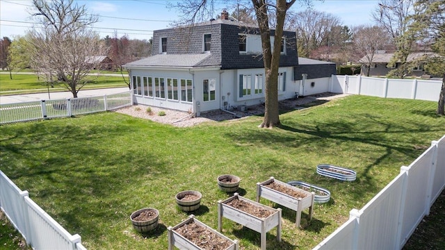 exterior space with a shingled roof, a vegetable garden, a yard, and a fenced backyard