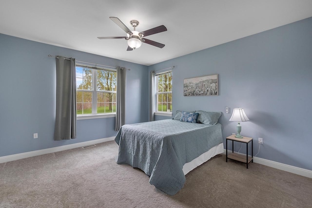 carpeted bedroom with baseboards, visible vents, and a ceiling fan