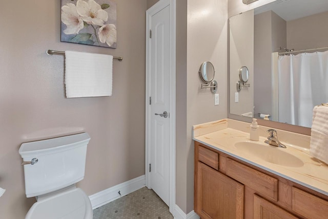 bathroom featuring vanity, toilet, a shower with shower curtain, and baseboards