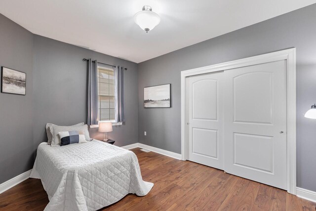 bedroom featuring baseboards, a closet, and wood finished floors