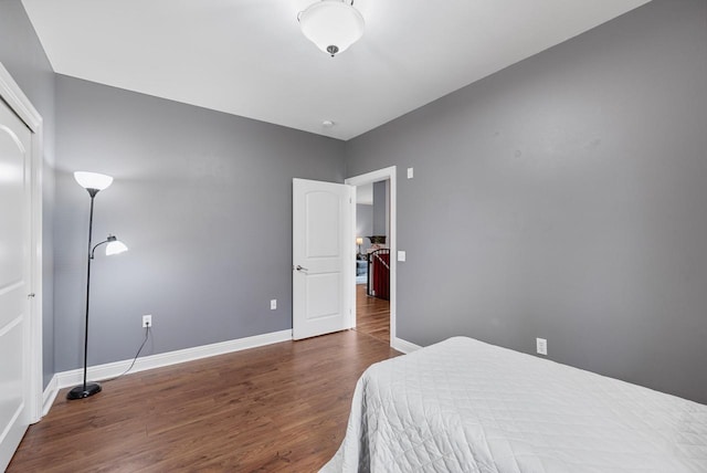 bedroom with wood finished floors and baseboards