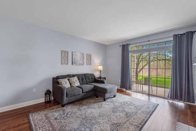 living area with baseboards, visible vents, and wood finished floors