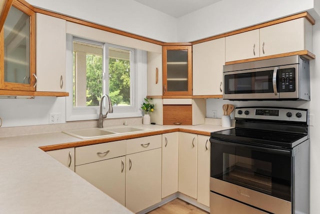 1511 Middleton St, Middleton, WI 53562 - kitchen featuring stainless steel appliances, light countertops, and glass insert cabinets