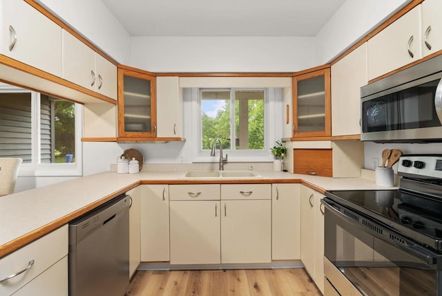 1511 Middleton St, Middleton, WI 53562 - kitchen with stainless steel appliances, light countertops, glass insert cabinets, and light wood finished floors