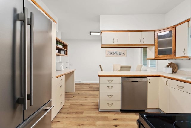 1511 Middleton St, Middleton, WI 53562 - kitchen with stainless steel appliances, light countertops, light wood-type flooring, and glass insert cabinets