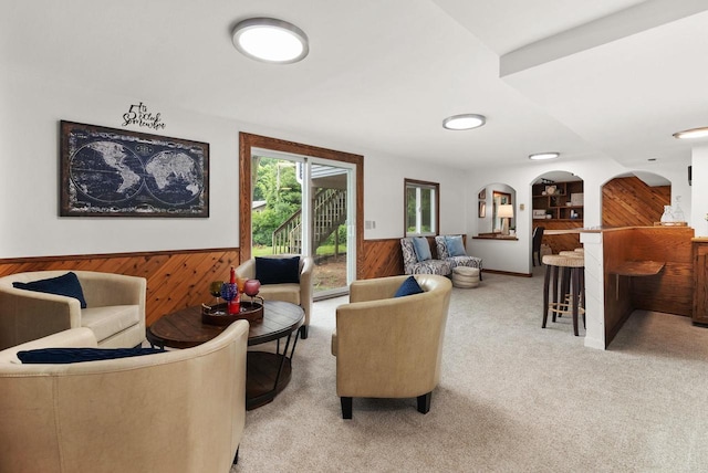 1511 Middleton St, Middleton, WI 53562 - living area with wood walls, arched walkways, a wainscoted wall, and light carpet