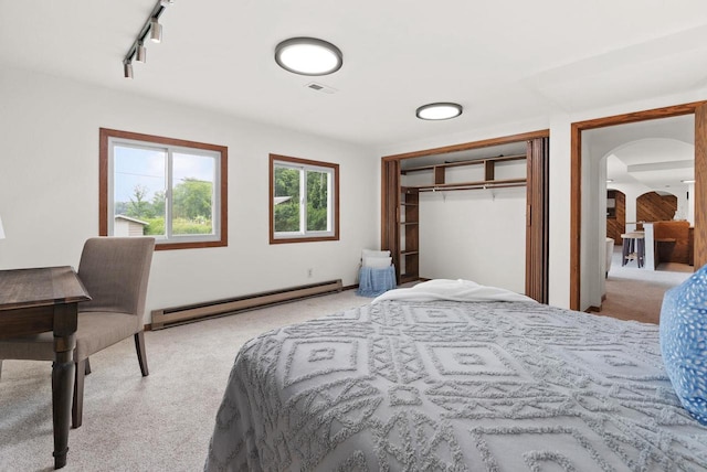 1511 Middleton St, Middleton, WI 53562 - carpeted bedroom with baseboard heating, arched walkways, track lighting, and a closet