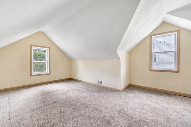 additional living space featuring visible vents, baseboards, lofted ceiling, and carpet floors