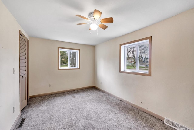 unfurnished bedroom featuring carpet flooring, baseboards, a closet, and visible vents