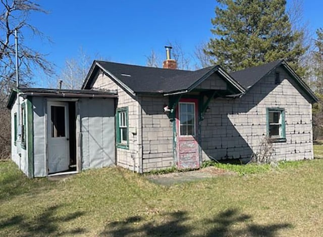 W7730 County Road Z, Pembine, WI 54156 - view of front facade featuring a chimney, a front yard, and concrete block siding