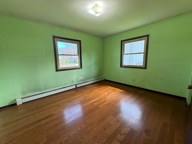 111 Grahl Ave, Eden, WI 53019 - spare room featuring baseboards, wood finished floors, baseboard heating, and a healthy amount of sunlight