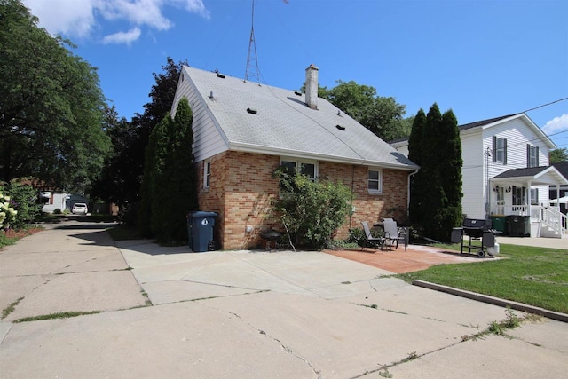 364 E 9th St, Fond Du Lac, WI 54935 - back of property with a patio, a chimney, and brick siding