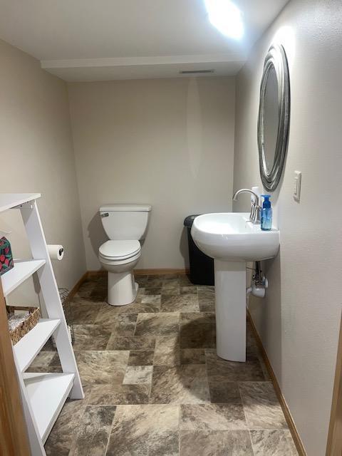 1075 Grant St, Fennimore, WI 53809 - half bathroom with stone finish flooring, baseboards, and toilet