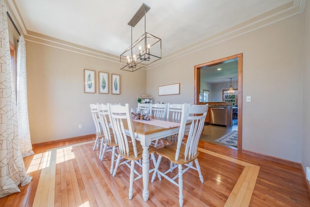 dining area with baseboards, crown molding, a chandelier, and wood-type flooring
