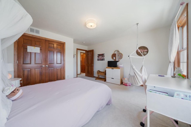 bedroom with light colored carpet, a closet, and visible vents