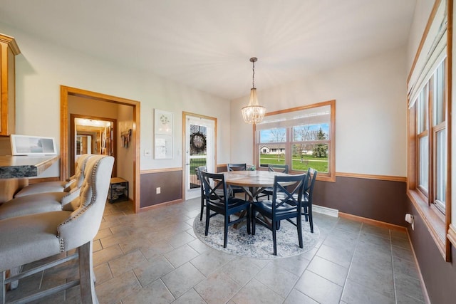 dining area with baseboards and a notable chandelier