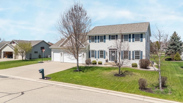colonial-style house with an attached garage, concrete driveway, and a front lawn
