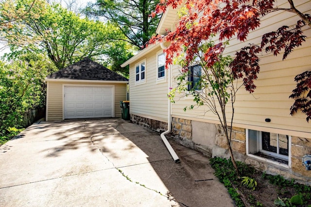 103 E Rollin St, Edgerton, WI 53534 - view of property exterior featuring an outbuilding, a detached garage, concrete driveway, and a shingled roof