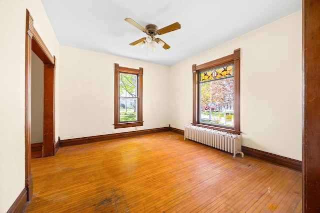 103 E Rollin St, Edgerton, WI 53534 - unfurnished bedroom with radiator heating unit, hardwood / wood-style flooring, baseboards, and ceiling fan