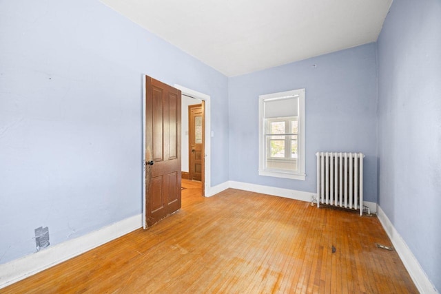 103 E Rollin St, Edgerton, WI 53534 - empty room featuring radiator heating unit, light wood-type flooring, and baseboards