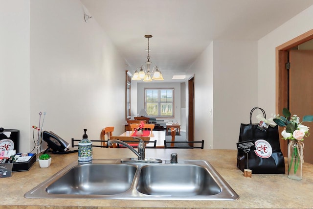 123 Center St Unit 301, Lake Geneva, WI 53147 - kitchen featuring decorative light fixtures, light countertops, a chandelier, and a sink