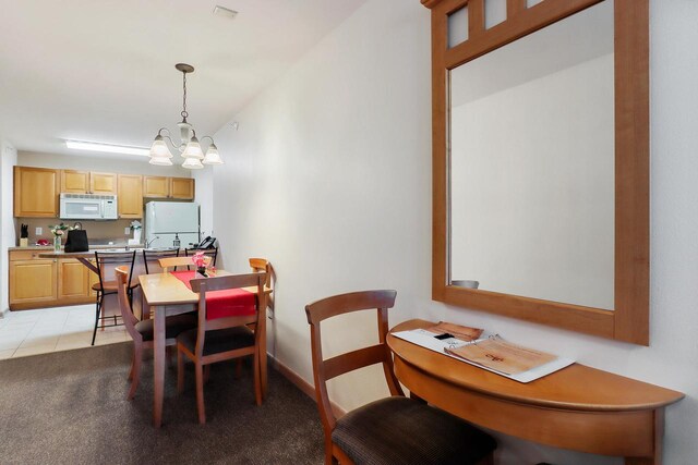 123 Center St Unit 301, Lake Geneva, WI 53147 - dining space featuring an inviting chandelier, light tile patterned floors, and light carpet