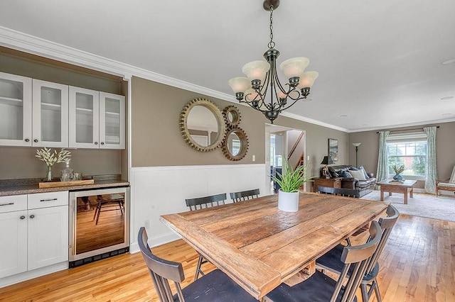 201 N Hillside Ter, Madison, WI 53705 - dining area featuring beverage cooler, light wood-type flooring, crown molding, and a chandelier