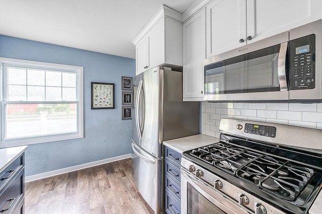 201 N Hillside Ter, Madison, WI 53705 - kitchen with appliances with stainless steel finishes, baseboards, light wood-style floors, backsplash, and light countertops