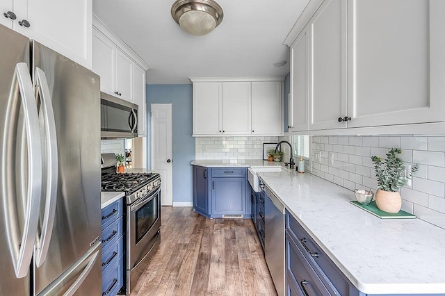 201 N Hillside Ter, Madison, WI 53705 - kitchen featuring stainless steel appliances, a sink, blue cabinetry, and dark wood-type flooring