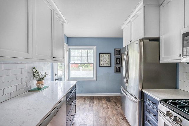 201 N Hillside Ter, Madison, WI 53705 - kitchen with wood finished floors, white cabinetry, light stone counters, and tasteful backsplash
