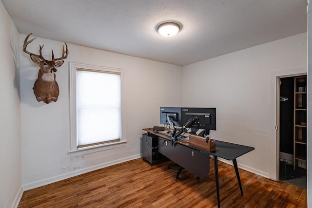 home office with a wealth of natural light, baseboards, and wood finished floors