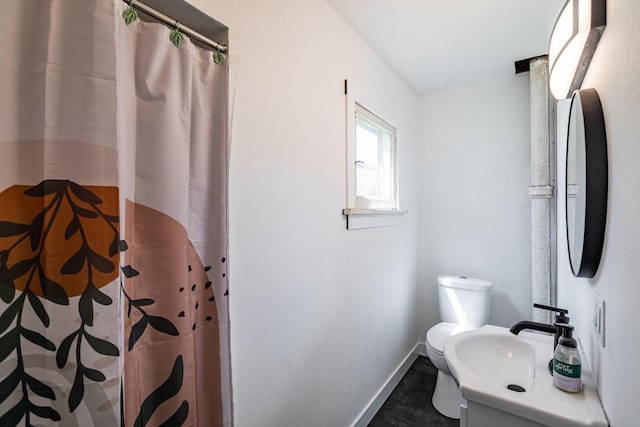 bathroom with toilet, baseboards, vanity, and a shower with curtain