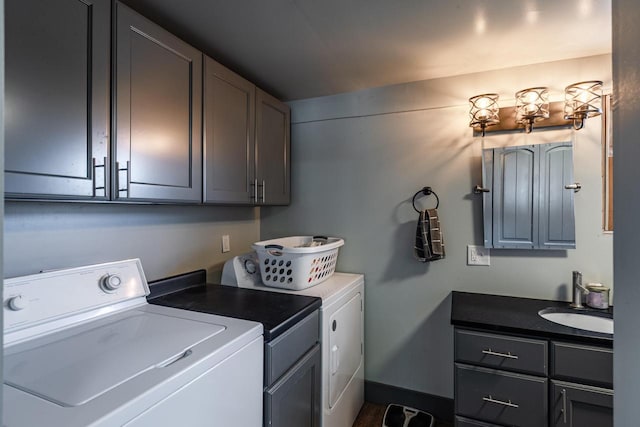 washroom with washing machine and clothes dryer, a sink, and cabinet space