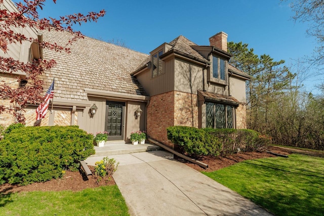view of front of home featuring a chimney and a front lawn