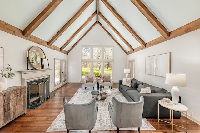 living area with high vaulted ceiling, beamed ceiling, dark wood finished floors, baseboards, and a high end fireplace