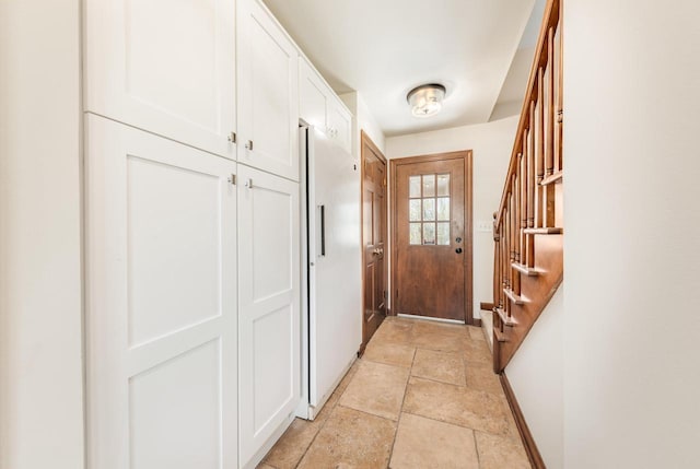 doorway to outside with stairs, light stone finish flooring, and baseboards