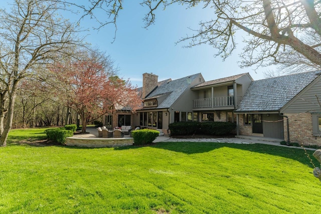rear view of house featuring a balcony, outdoor lounge area, a patio, and a yard