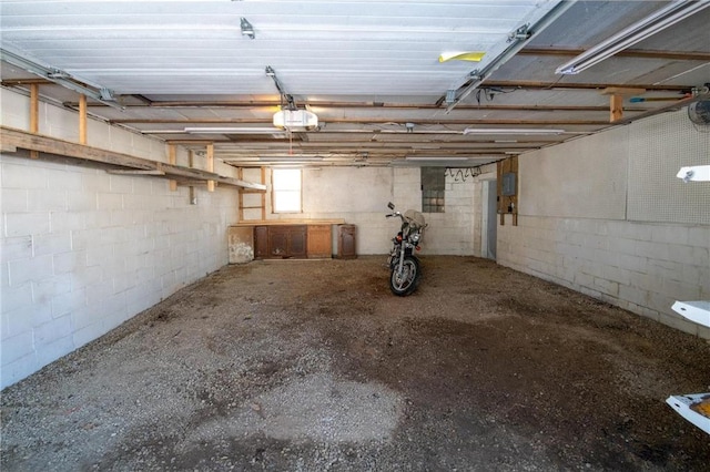 basement featuring concrete block wall and a garage