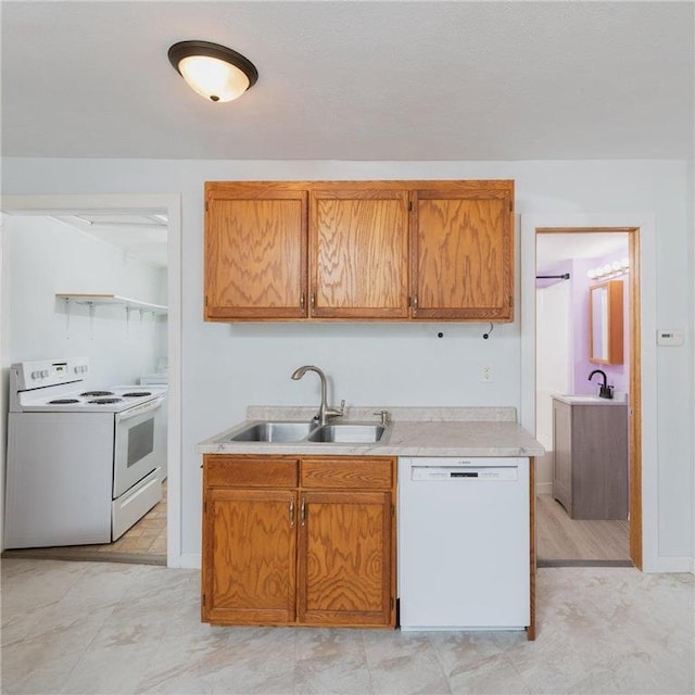 kitchen with brown cabinetry, white appliances, light countertops, and a sink