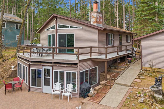 1074 E Queens Way, Nekoosa, WI 54457 - rear view of property with outdoor dining area, a patio area, a chimney, and a deck