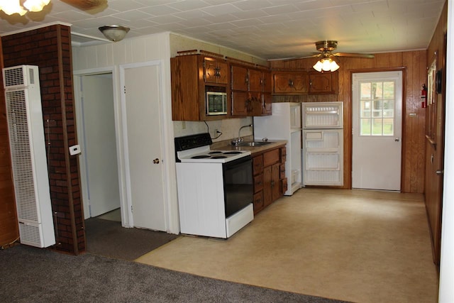 kitchen with a ceiling fan, a sink, a heating unit, stainless steel microwave, and range with electric stovetop
