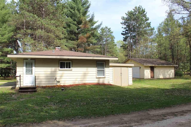 exterior space with a yard, an outbuilding, a garage, and a storage shed