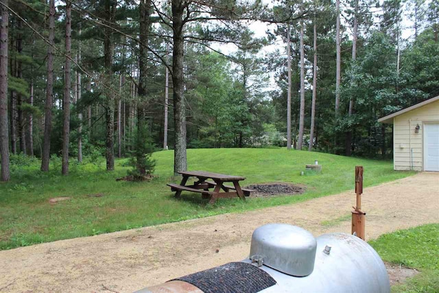 surrounding community featuring a yard and a forest view
