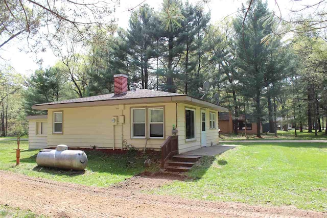 view of front of property with a chimney and a front lawn